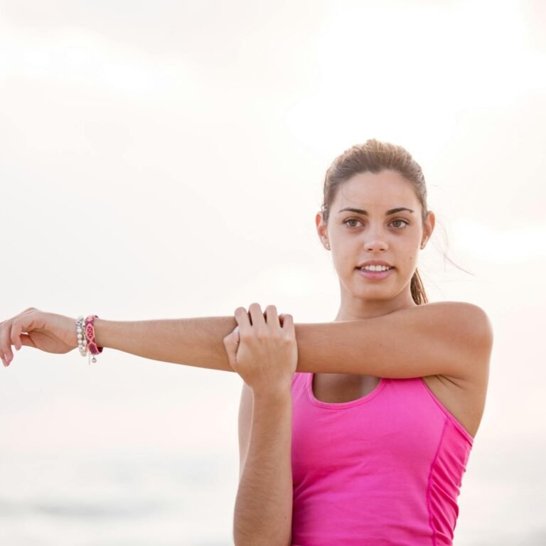 Young woman enjoying a relaxing stretch on a sunny Australian beach. Perfect for lifestyle and fitness themes.